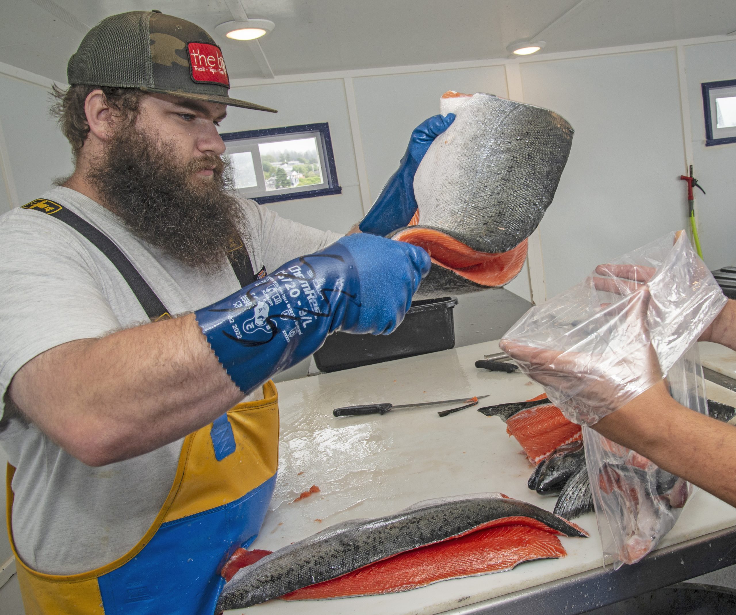 A worker at Chelsea Rose Seafood places salmon in a bag for a customer.