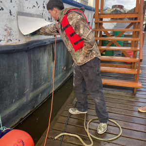 A student puts one hand in a scupper and a foot in a bight.