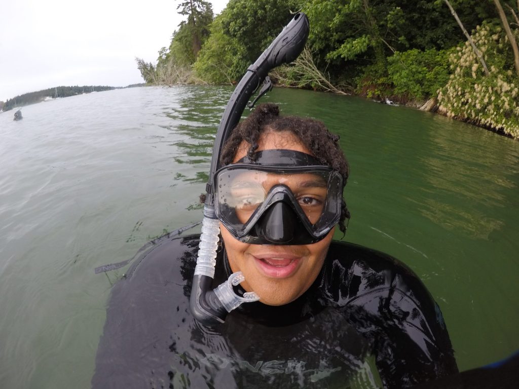 Selfie of person in water with mask and snorkel. 