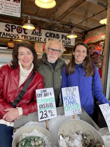 Three authors stand in front of bucket of oysters