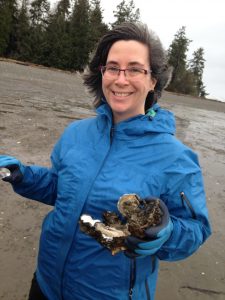 Person on beach holding oysters