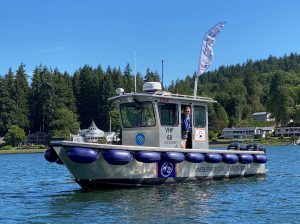 A mobile pumpout boat in the water with a person looking out through the cabin