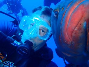 Russell Callender poses with a fish while scuba diving