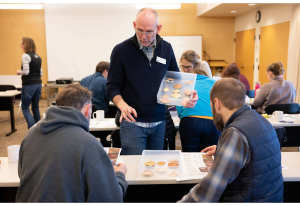 An instructor shows trainees the molted shells of different crab species found on Washington beaches during a Molt Search training.