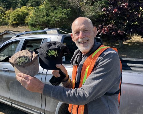 What difference ten years in the sun makes! Jeff Malinoff poses with his original hat from the beginning of Crab Team (2015) next to his replacement hat. Photo Credit: H. Brown/WSG What difference ten years in the sun makes! Jeff Malinoff poses with his original hat from the beginning of Crab Team (2015) next to his replacement hat. Photo Credit: H. Brown/WSG